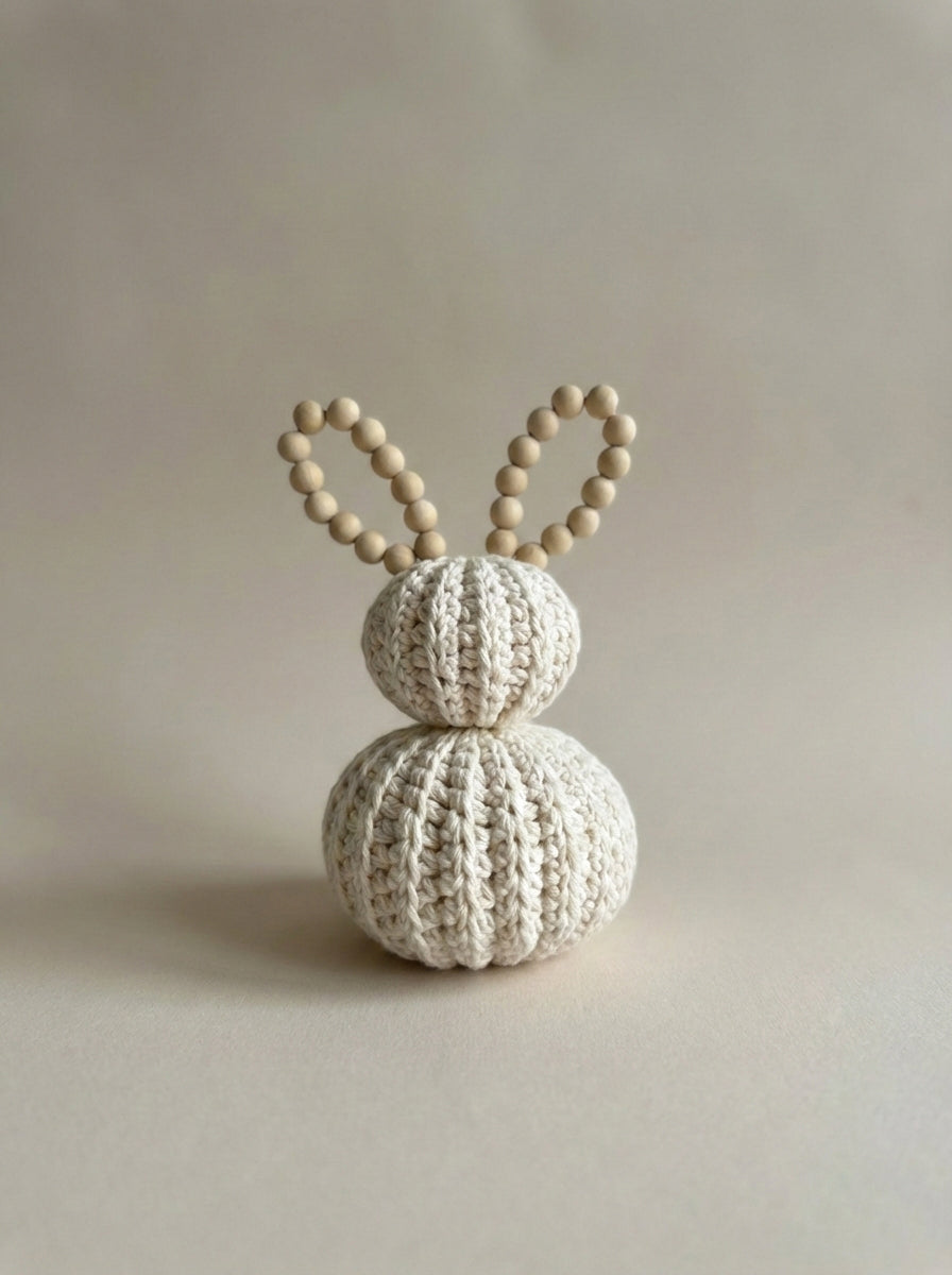 Decorative item with crocheted design and wooden bead ears on a plain background. Crocheted nursery room decor or crocheted easter decoration. Crochet pastel bunnies. Babyshower gift. Handmade gift. Animo Design. Animodesignshop.