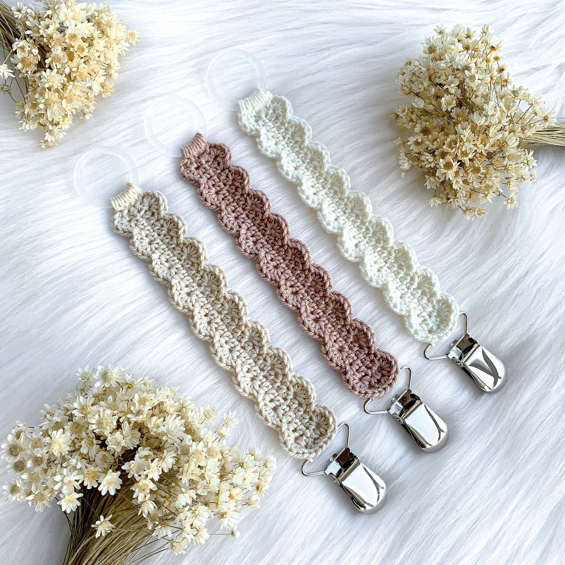 Crochet pacifier clip pattern Ester with Scandinavian-inspired handmade baby styling and soft neutral textures.