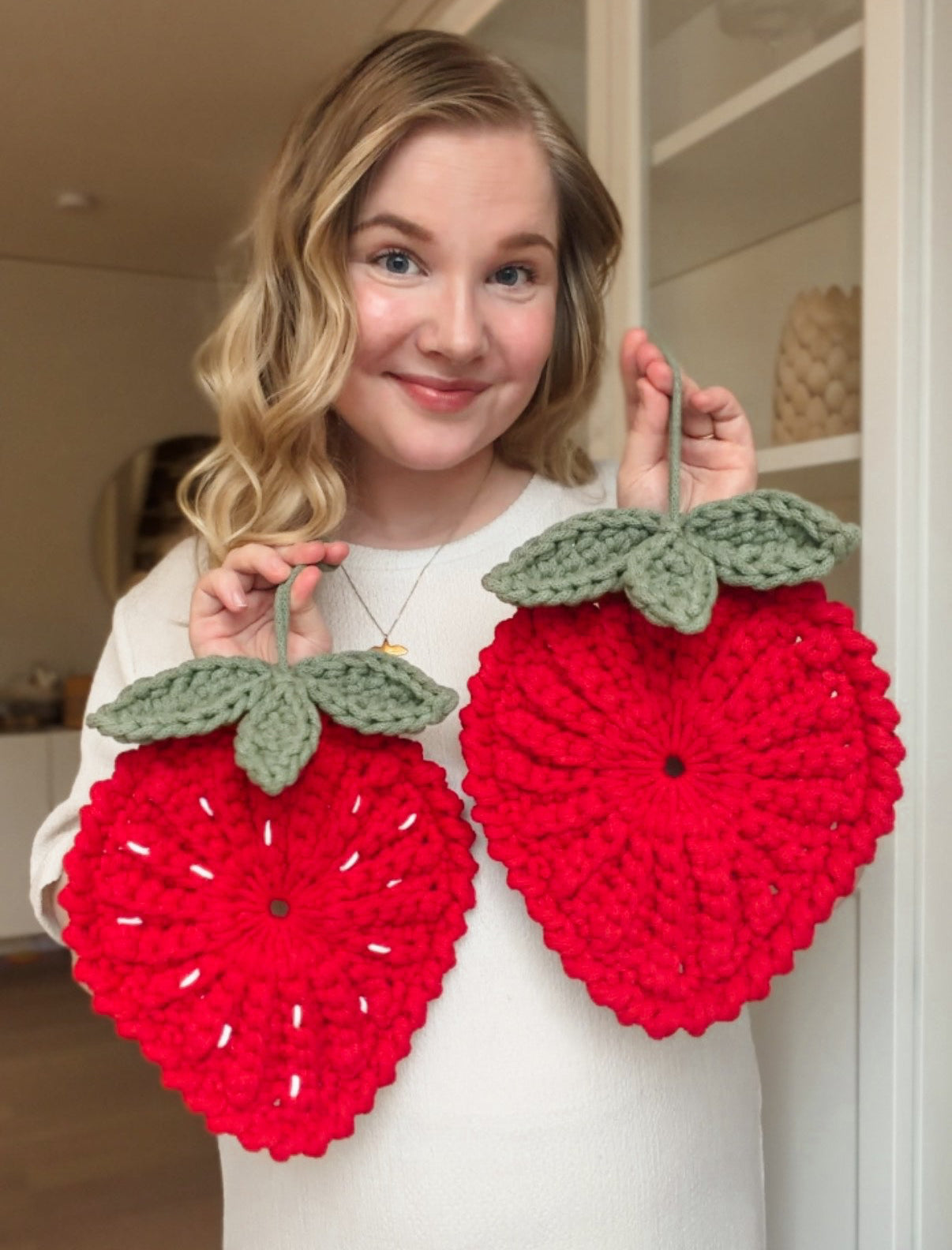 Modern crochet strawberry trivet pattern. Animo Design founder holding it.
