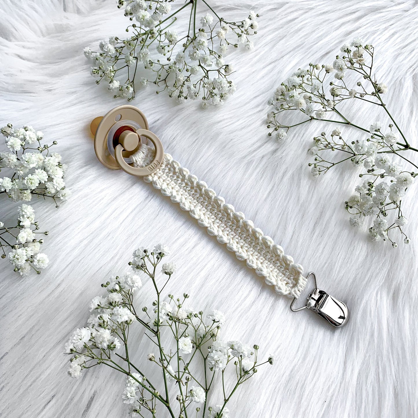 Easy crochet baby pacifier clip pattern with soft yarn and timeless Scandinavian-inspired styling.