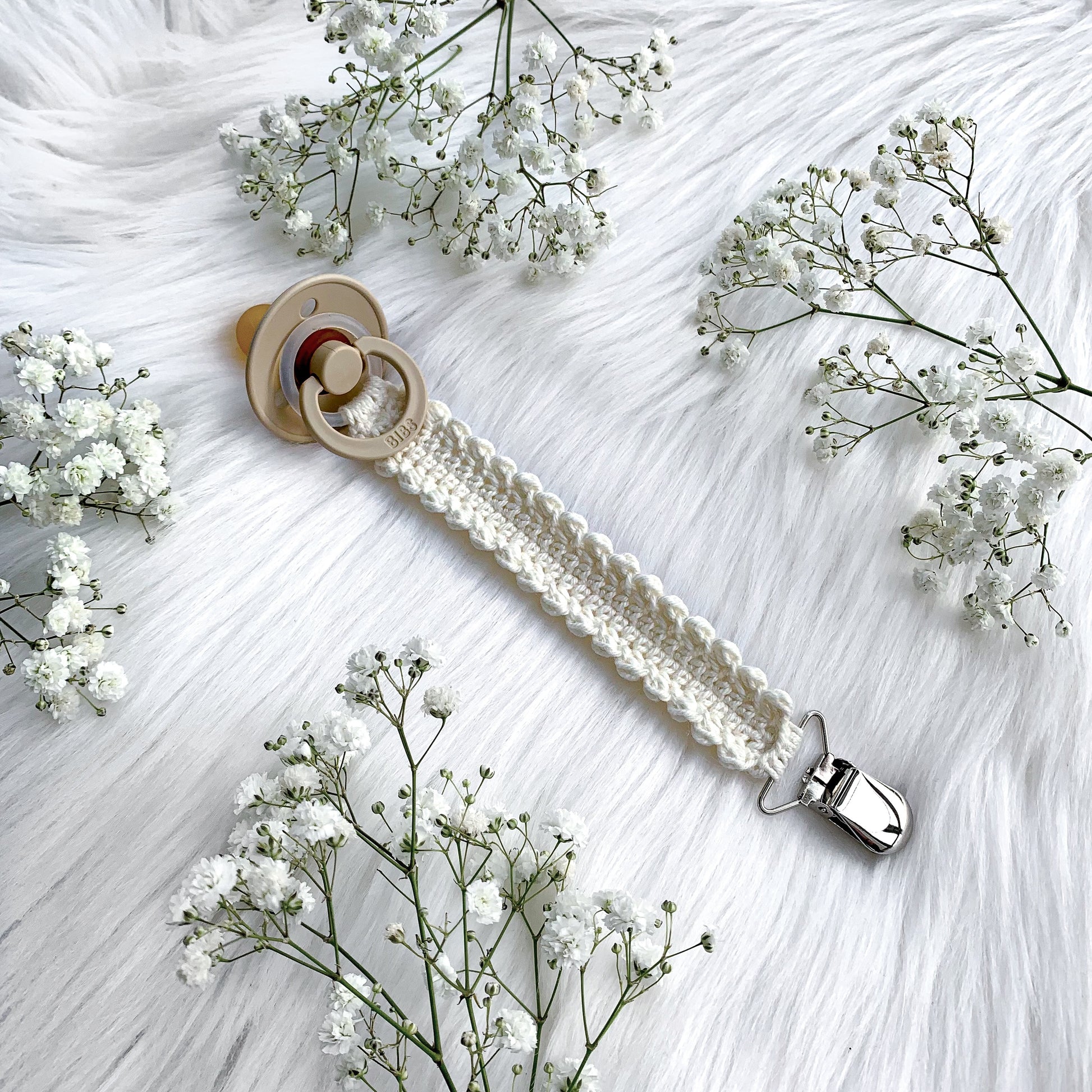 Easy crochet baby pacifier clip pattern with soft yarn and timeless Scandinavian-inspired styling.