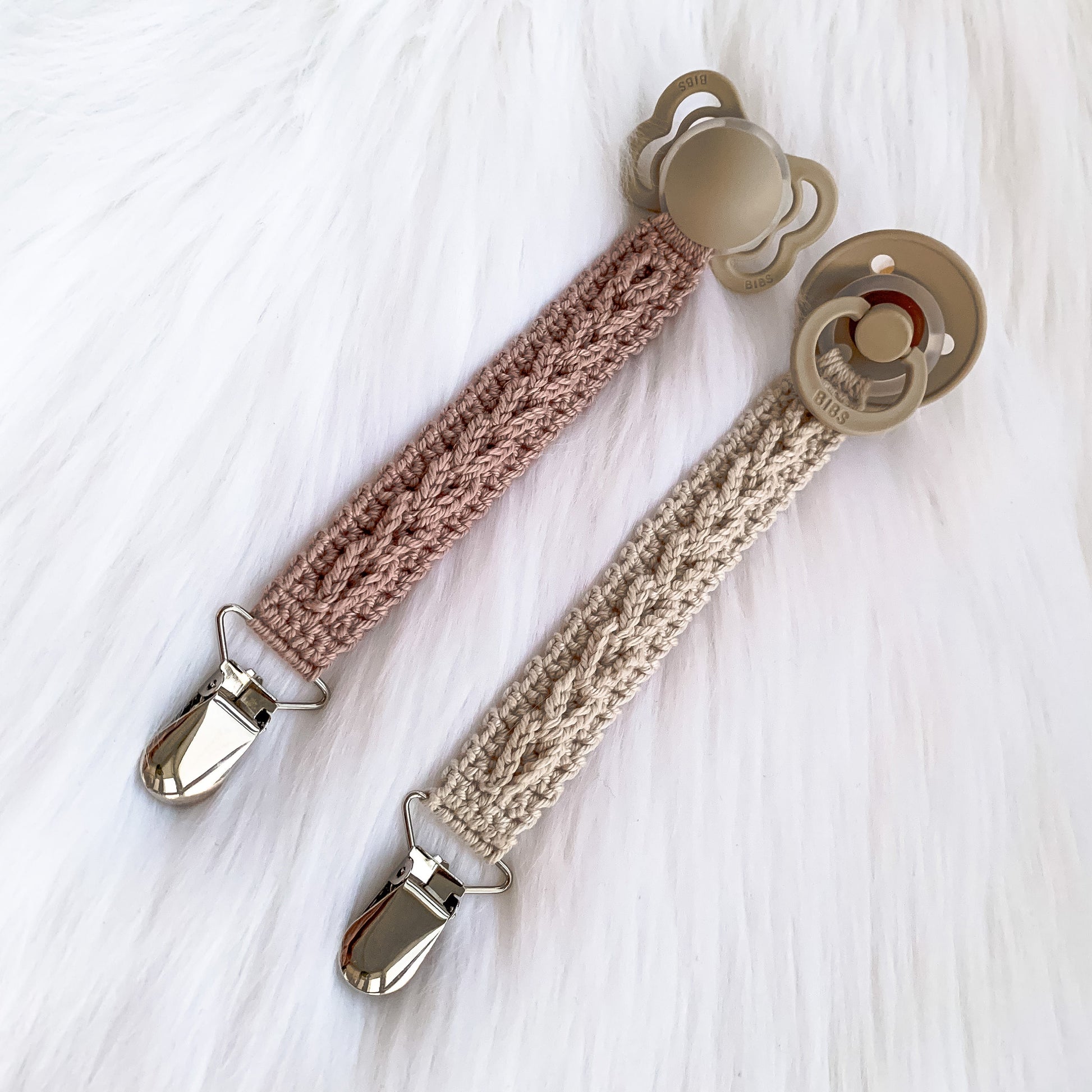 Handmade crochet baby pacifier clip pattern with textured details and Scandinavian-inspired styling.