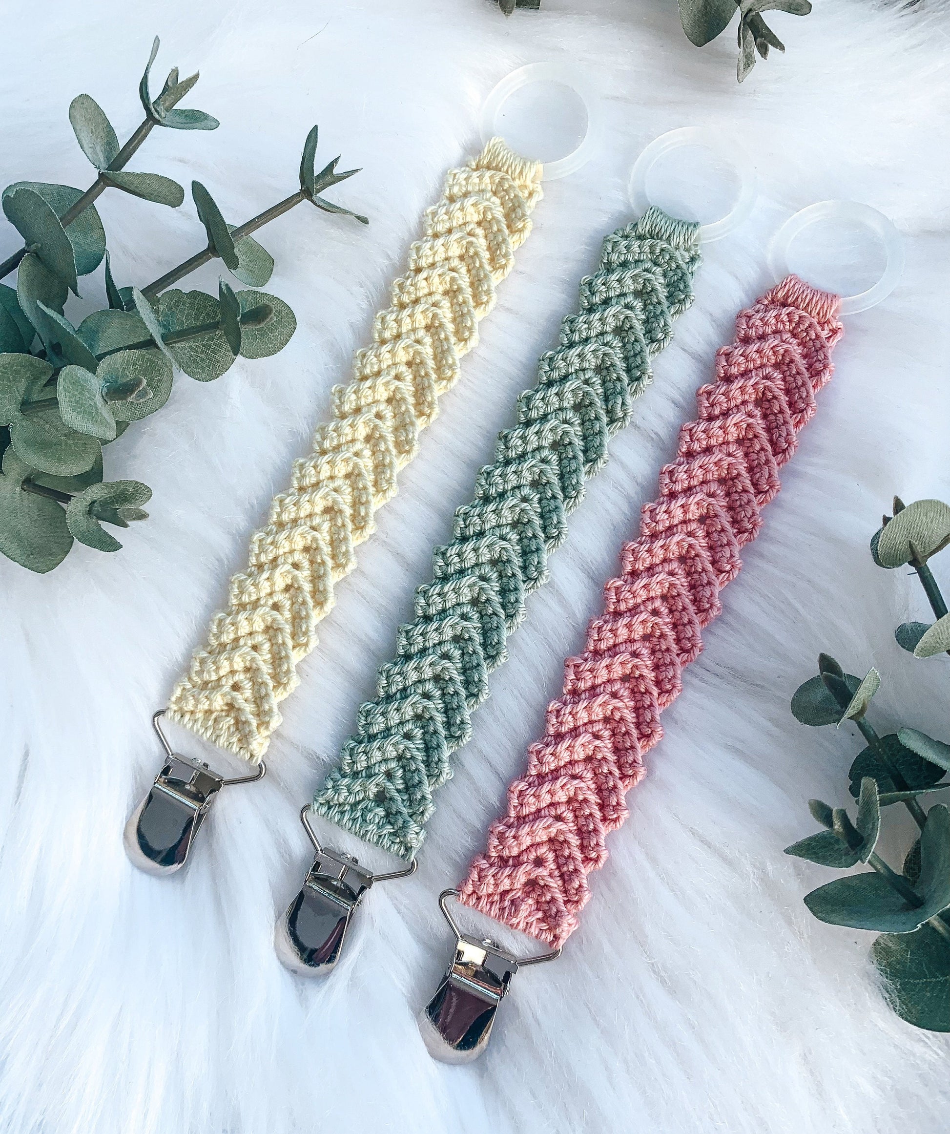 Handmade crochet baby pacifier holder pattern designed for modern nursery decor and baby gifts.