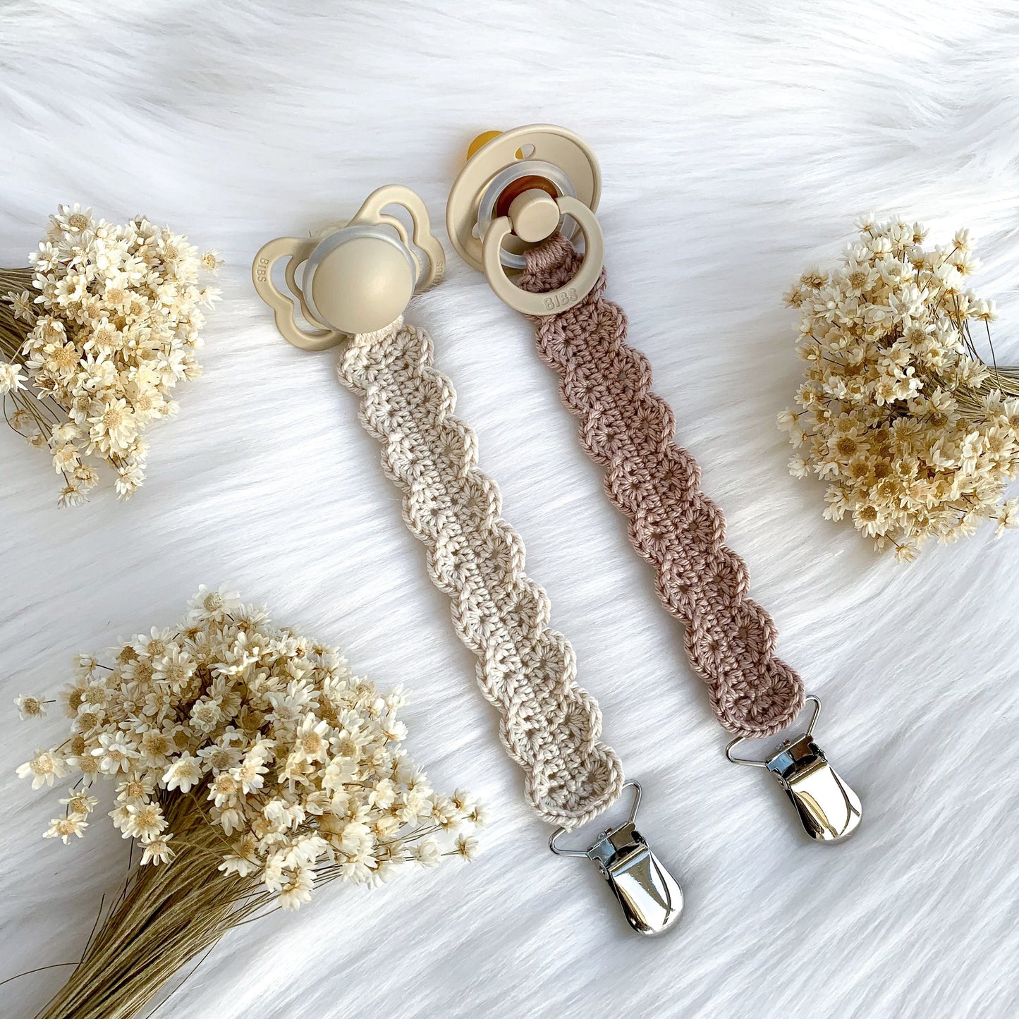 Handmade crochet baby pacifier holder pattern with textured details and Scandinavian-inspired styling.