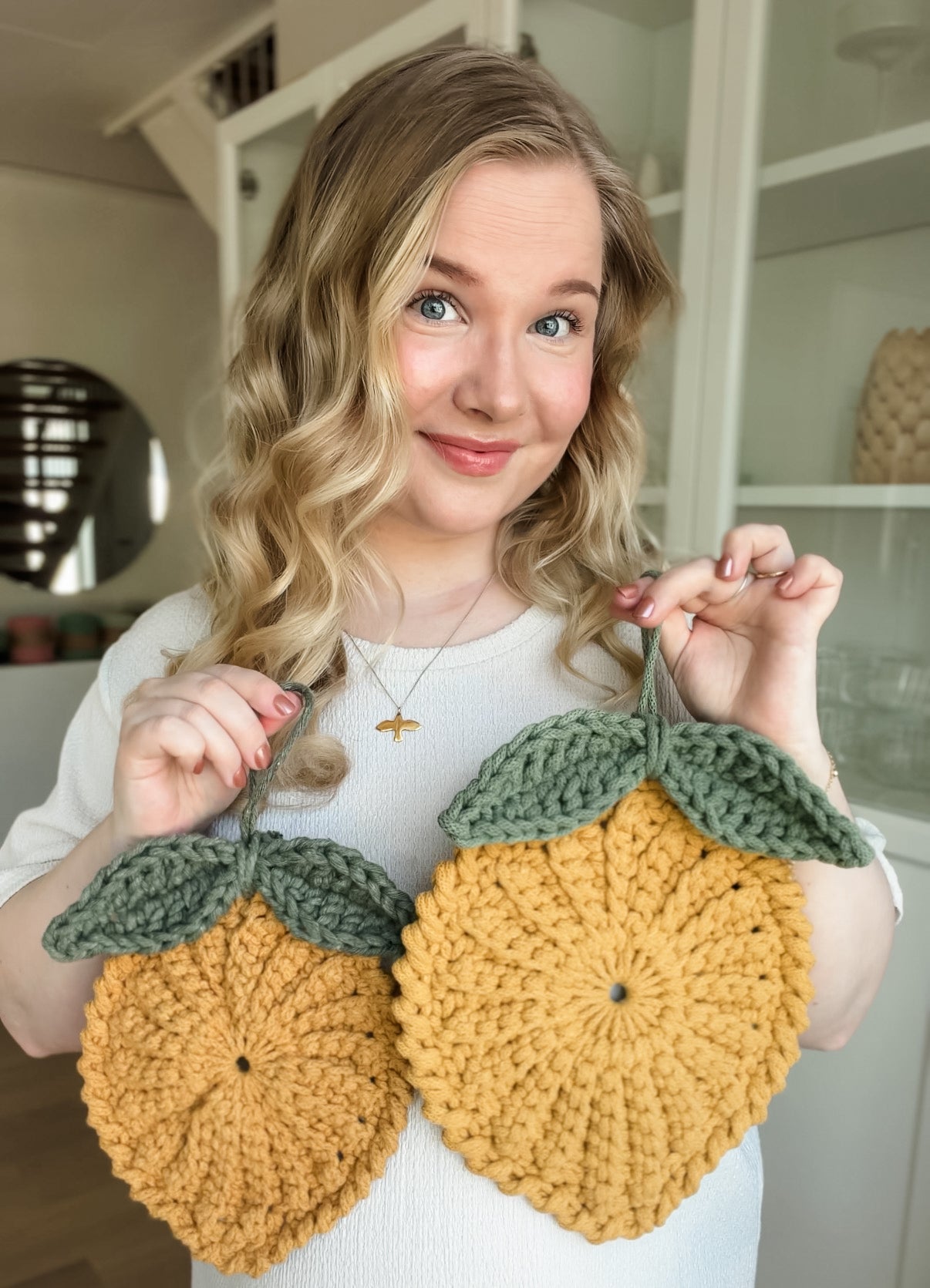 Modern crochet lemon trivet pattern shown for size reference. Animo Design founder holding it.