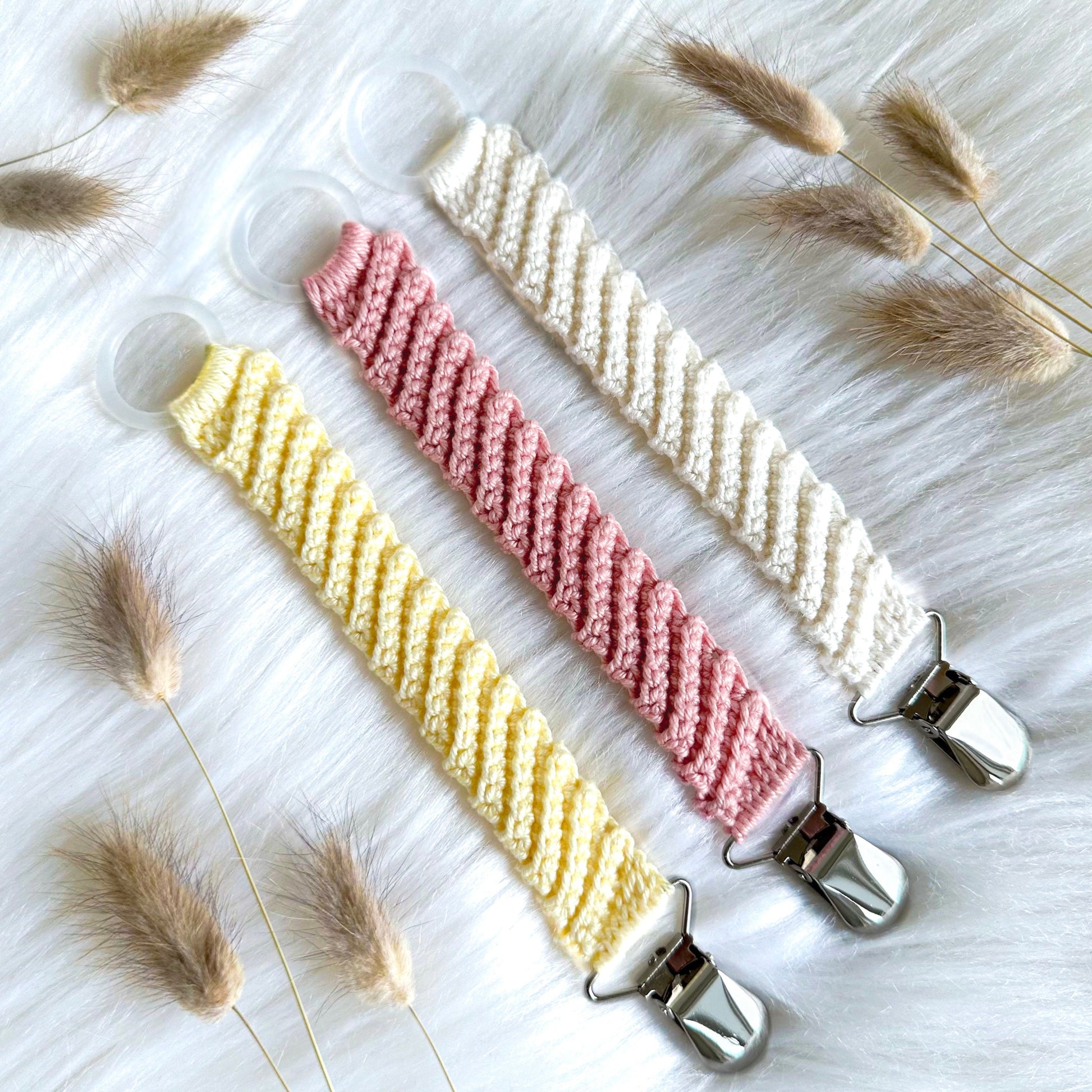 Neutral crochet pacifier holder pattern with timeless Scandinavian-inspired baby aesthetic and soft yarn textures.