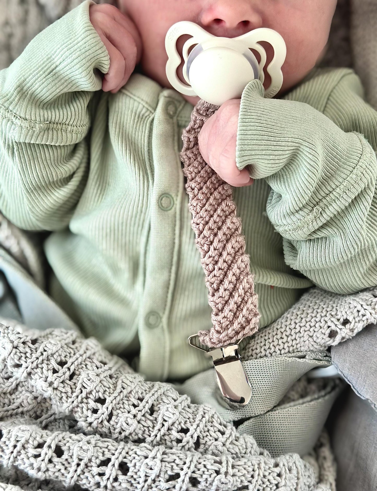 Scandinavian crochet pacifier clip pattern with minimalist handmade baby accessory design and cozy textures.