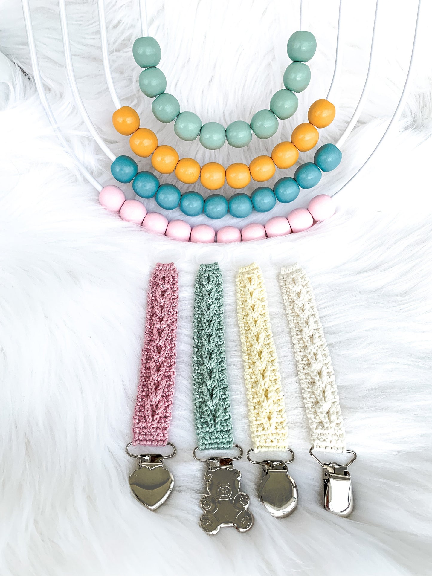 Scandinavian crochet pacifier holder pattern featuring soft yarn textures and timeless handmade baby aesthetic.