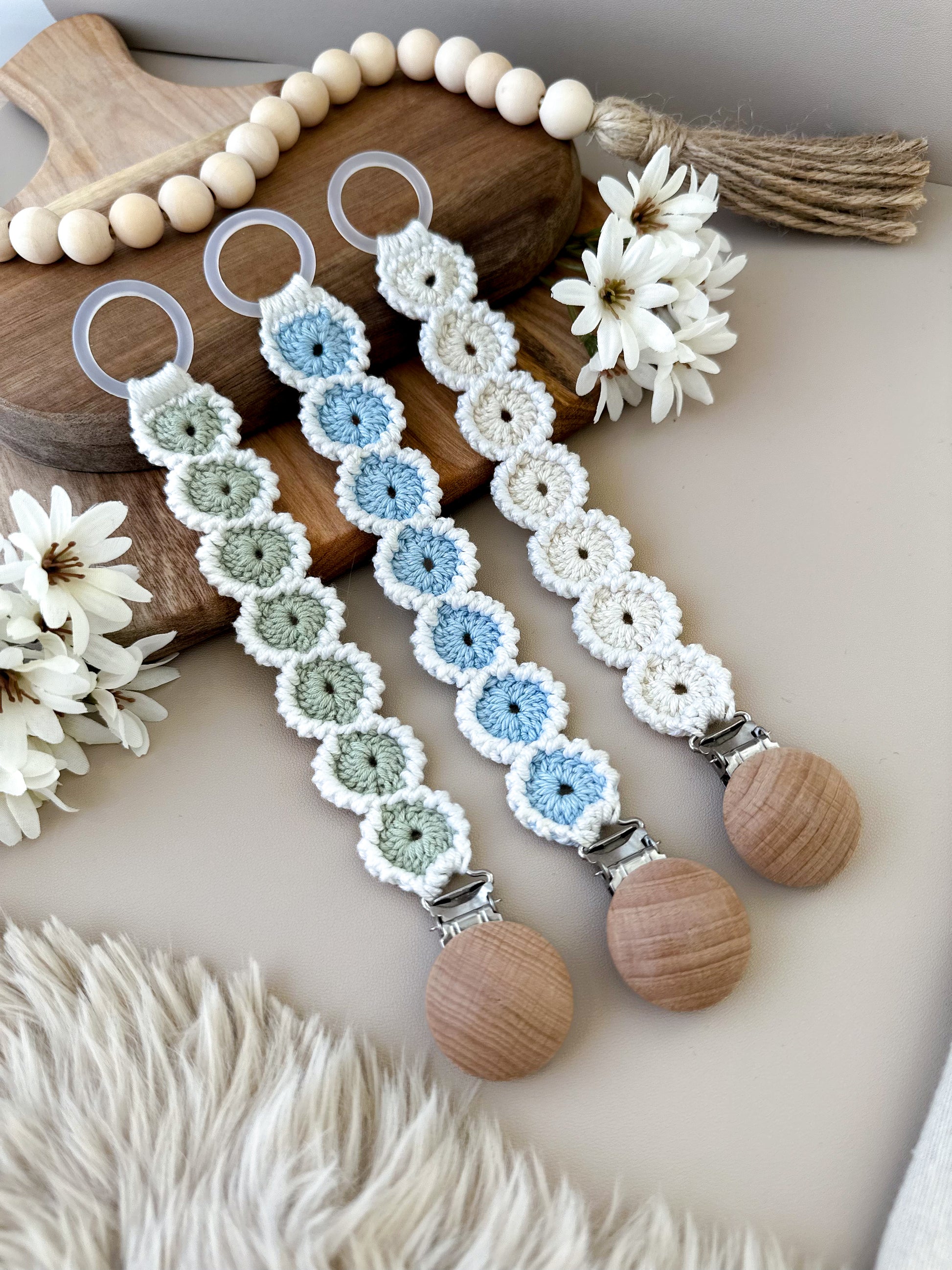 Virkad napphållare med blomma i ljus, skandinavisk stil. En personlig och somrig present till babyshower för nyblivna föräldrar.